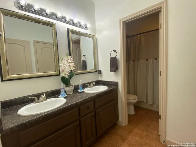 a bathroom with a double vanity sink and a mirror