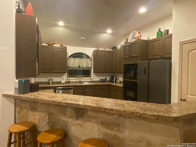 a kitchen with kitchen island a sink stainless steel appliances and cabinets