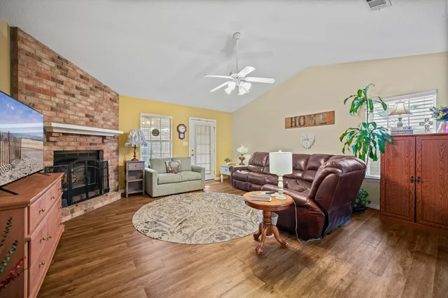 a living room with furniture floor to ceiling window and a fireplace