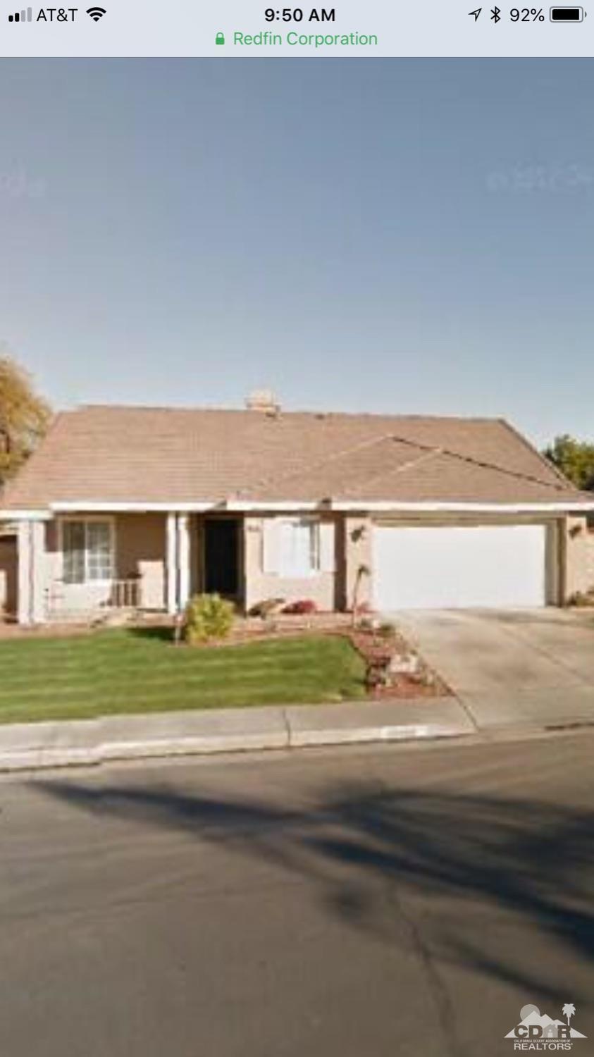 49084 Violet Street Indio, CA 92201 - Photo 3 of 14 a front view of a house with a yard