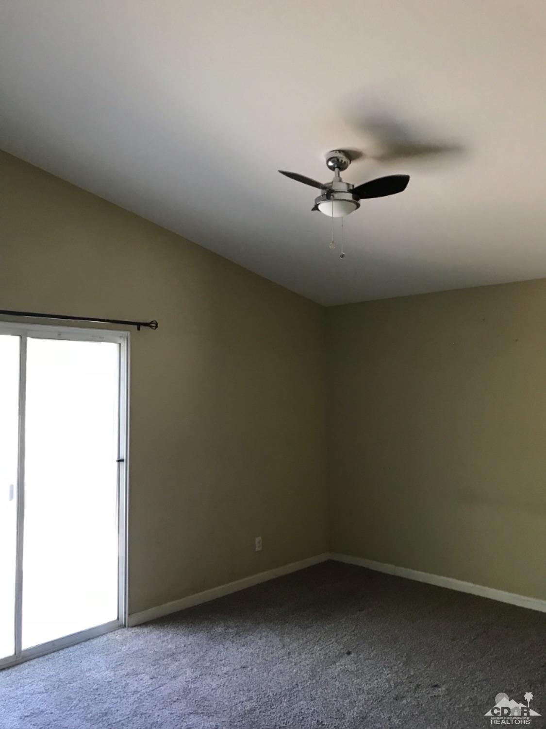 49084 Violet Street Indio, CA 92201 - Photo 9 of 14 an empty room with a ceiling fan and window