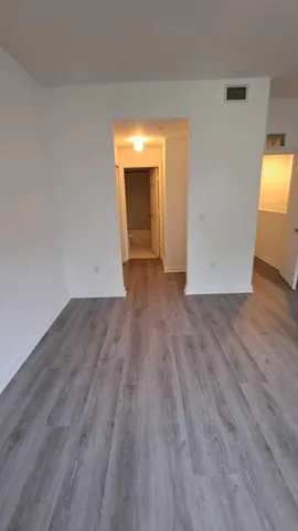 a view of a room with wooden floor and a window