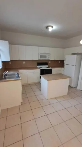 a kitchen with stainless steel appliances a sink stove and white cabinets