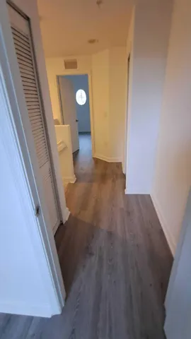 a view of a hallway with wooden floor and staircase