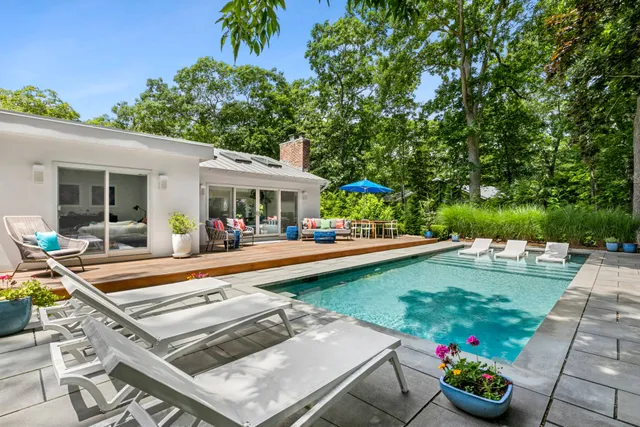 a view of a house with swimming pool and sitting area