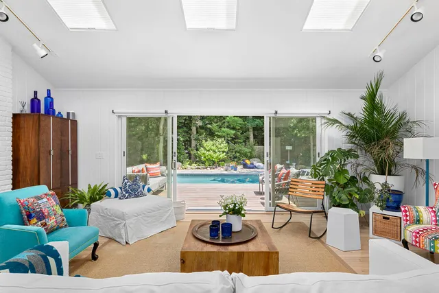 a living room with furniture potted plant and a large window