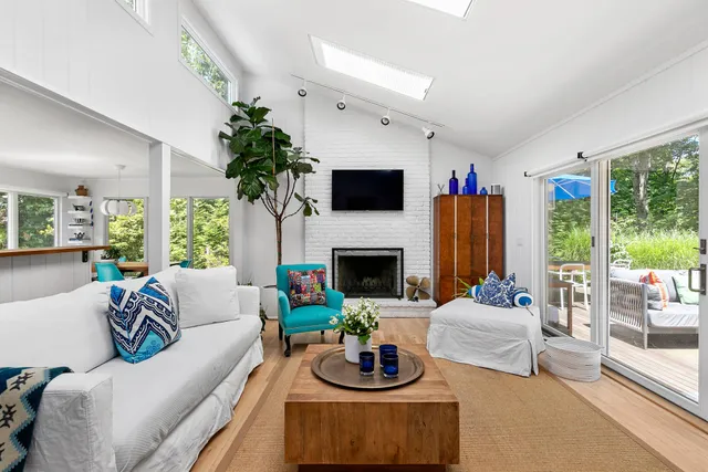 a living room with furniture fireplace and a large window