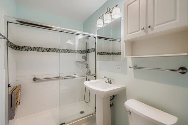 a bathroom with a sink a toilet and shower