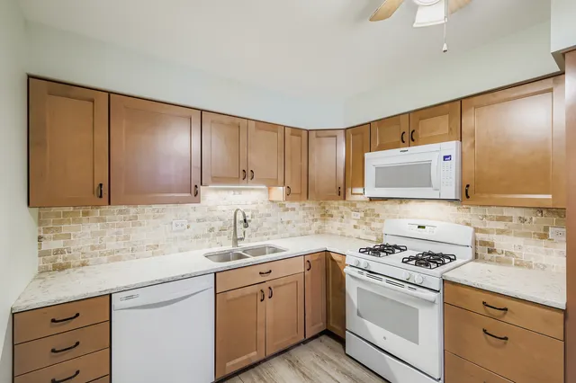 a kitchen with granite countertop a sink a stove and cabinets