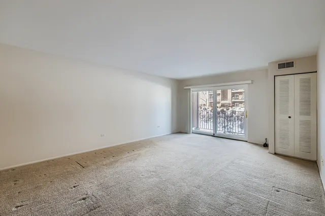 an empty room with windows and closet in it