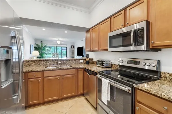 a kitchen with stainless steel appliances granite countertop a stove a sink and a microwave