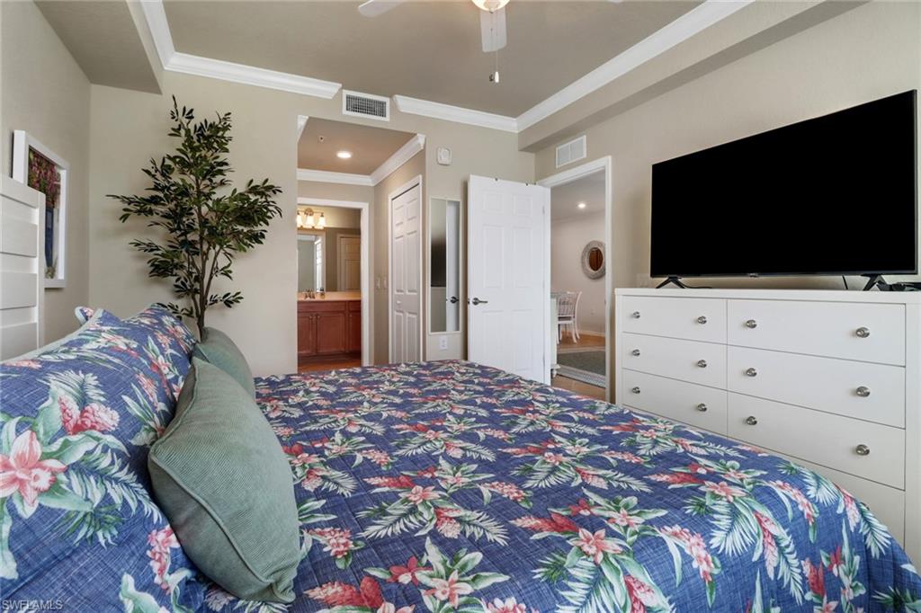 9560 Trevi Court, Unit 4814 Naples, FL 34113 - Photo 15 of 42 a bedroom with a bed and a flat screen tv in it