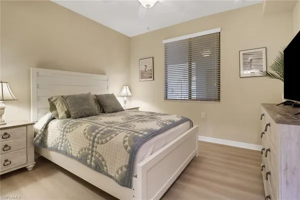 a bedroom with a bed and a flat tv screen on a dresser