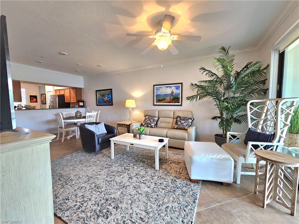 9560 Trevi Court, Unit 4814 Naples, FL 34113 - Photo 7 of 42 a living room with furniture and a chandelier