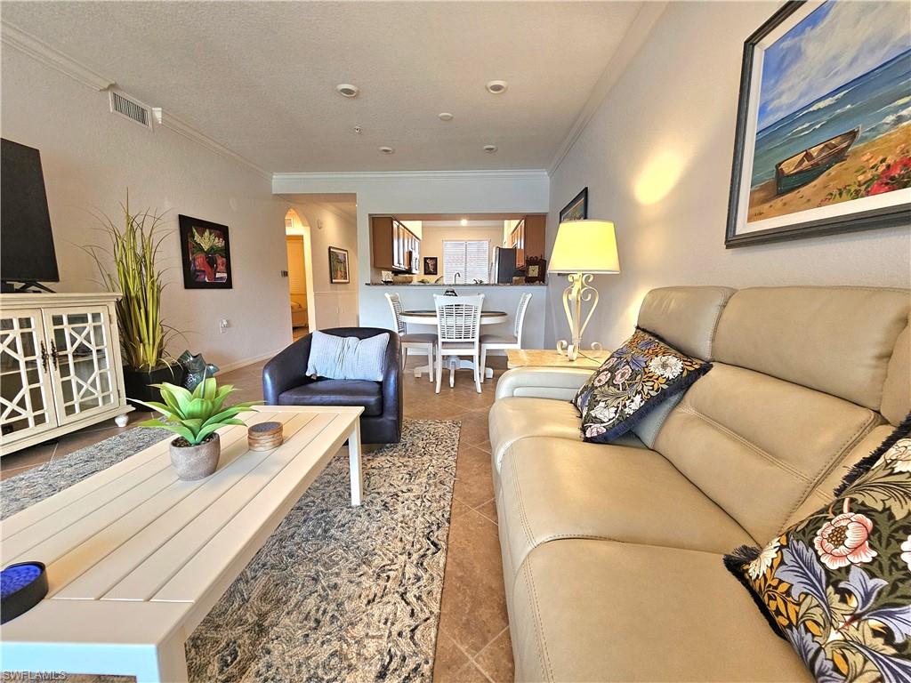 9560 Trevi Court, Unit 4814 Naples, FL 34113 - Photo 8 of 42 a living room with furniture and a flat screen tv