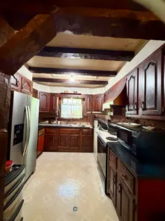 a large kitchen with stainless steel appliances granite countertop a stove and a refrigerator