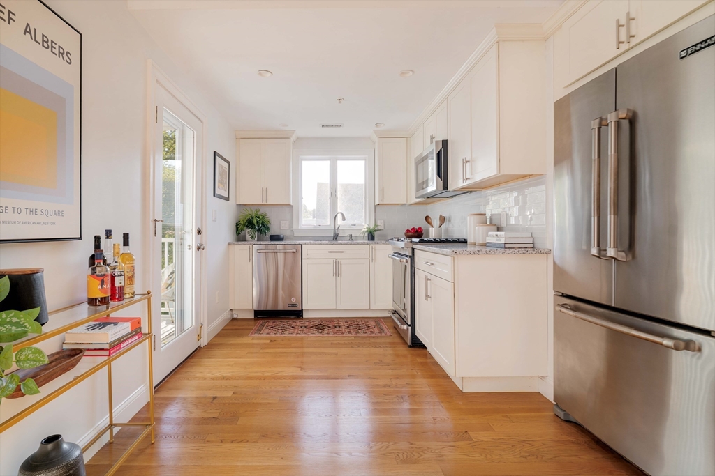 59 Berkeley Street, Unit 3 Somerville, MA 02143 - Photo 6 of 18 a kitchen with stainless steel appliances a sink stove refrigerator and cabinets