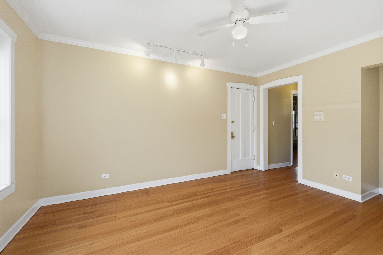 1014 West Barry Avenue, Unit 1 Chicago, IL 60657 - Photo 5 of 17 an empty room with wooden floor and fan