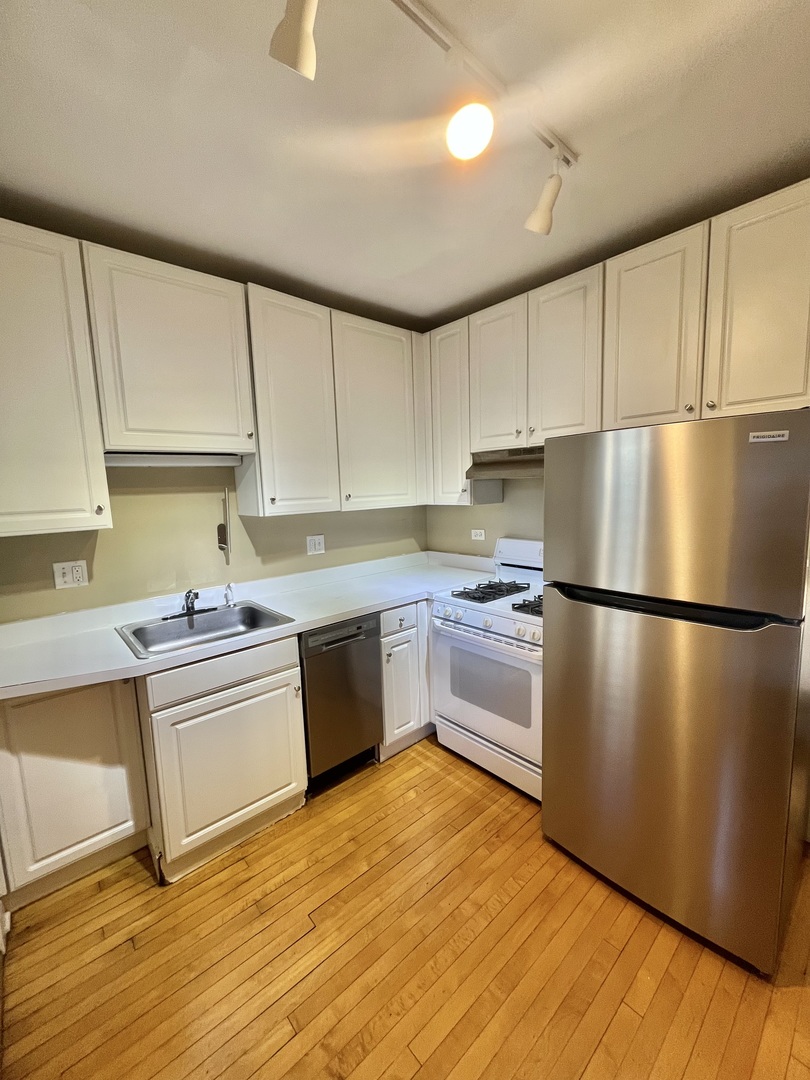 1014 West Barry Avenue, Unit 1 Chicago, IL 60657 - Photo 6 of 17 a kitchen with stainless steel appliances granite countertop a refrigerator sink and stove