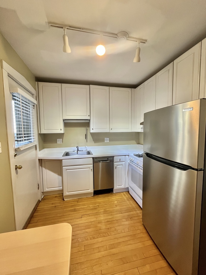 1014 West Barry Avenue, Unit 1 Chicago, IL 60657 - Photo 7 of 17 a kitchen with a refrigerator a stove top oven a sink and cabinets