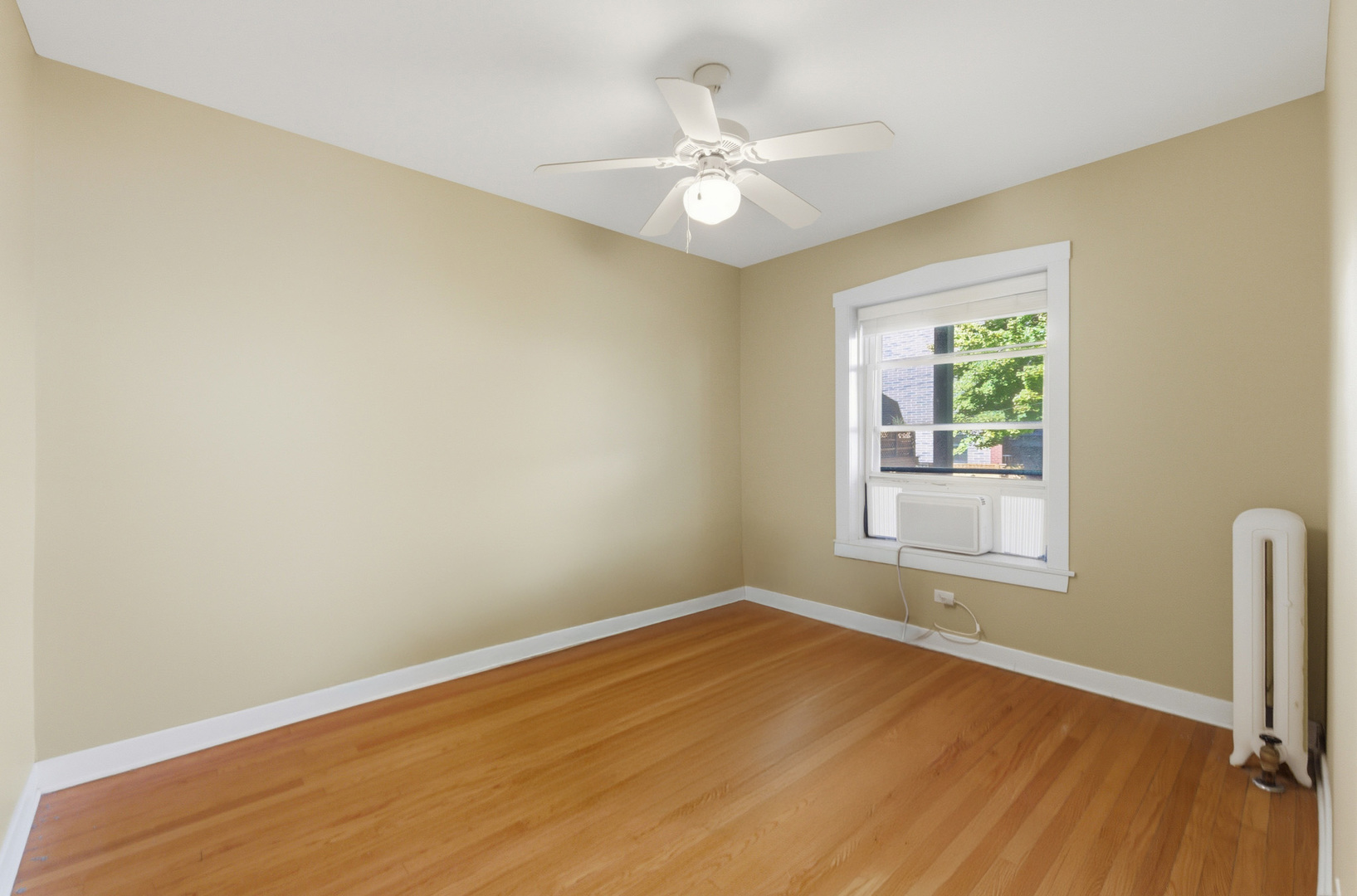 1014 West Barry Avenue, Unit 1 Chicago, IL 60657 - Photo 9 of 17 an empty room with a chandelier fan and windows