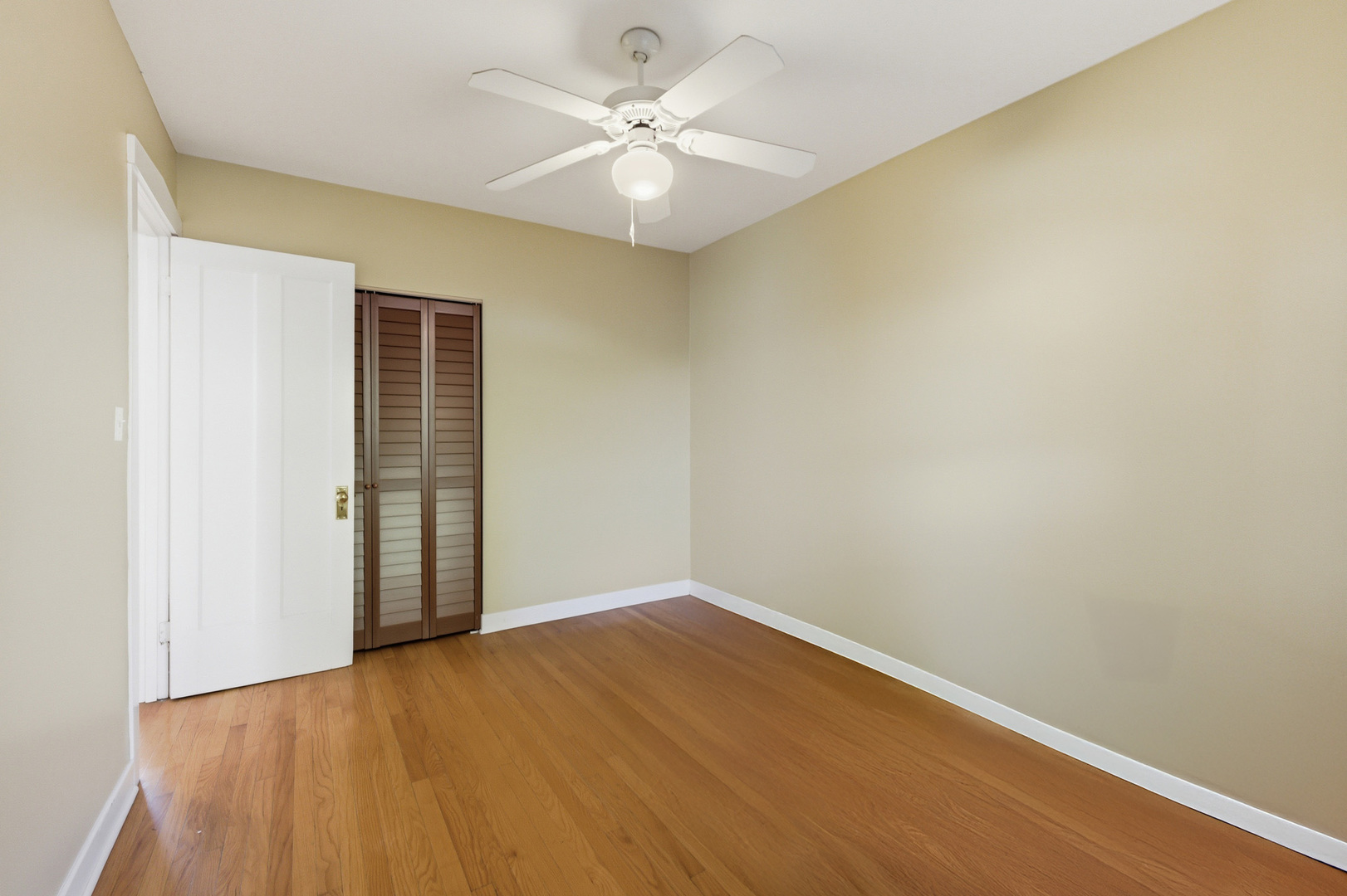 1014 West Barry Avenue, Unit 1 Chicago, IL 60657 - Photo 10 of 17 an empty room with a chandelier fan and wooden floor