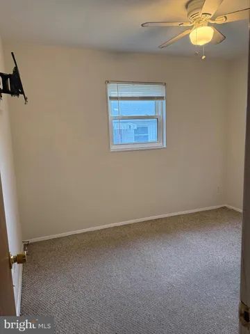 an empty room with a chandelier fan