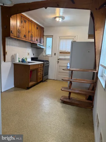 a kitchen with kitchen island a counter top space a sink stainless steel appliances and cabinets