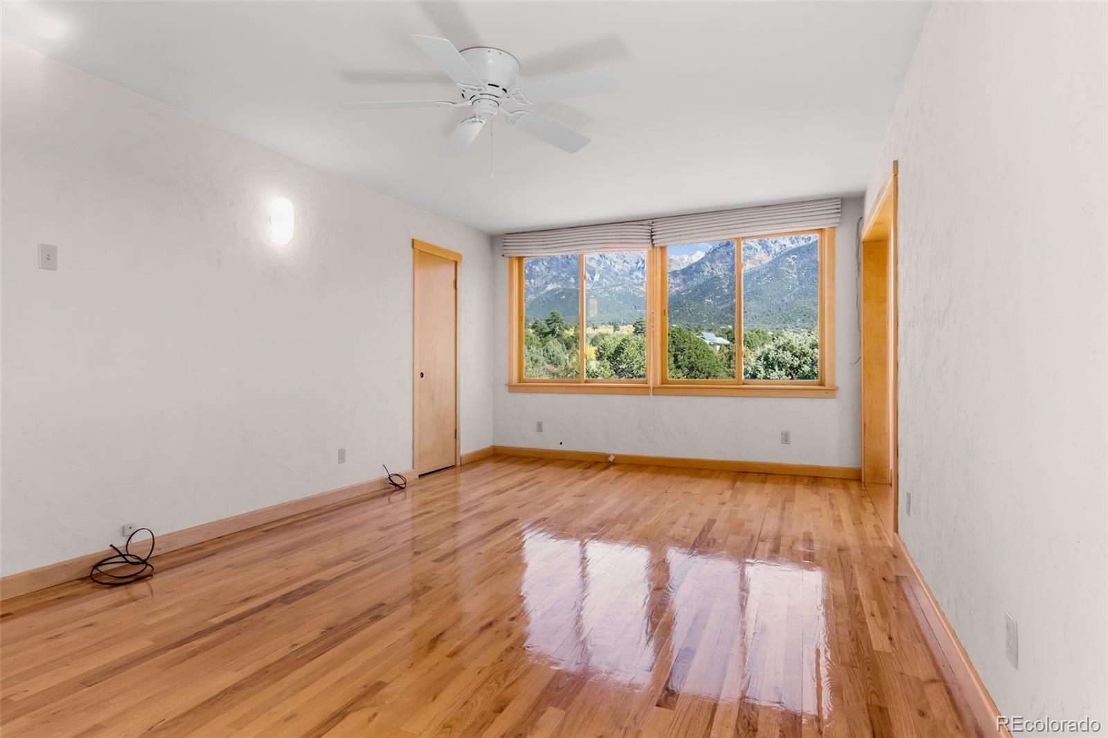 1507 Wagon Wheel Road Crestone, CO 81131 - Photo 35 of 50 an empty room with wooden floor and windows