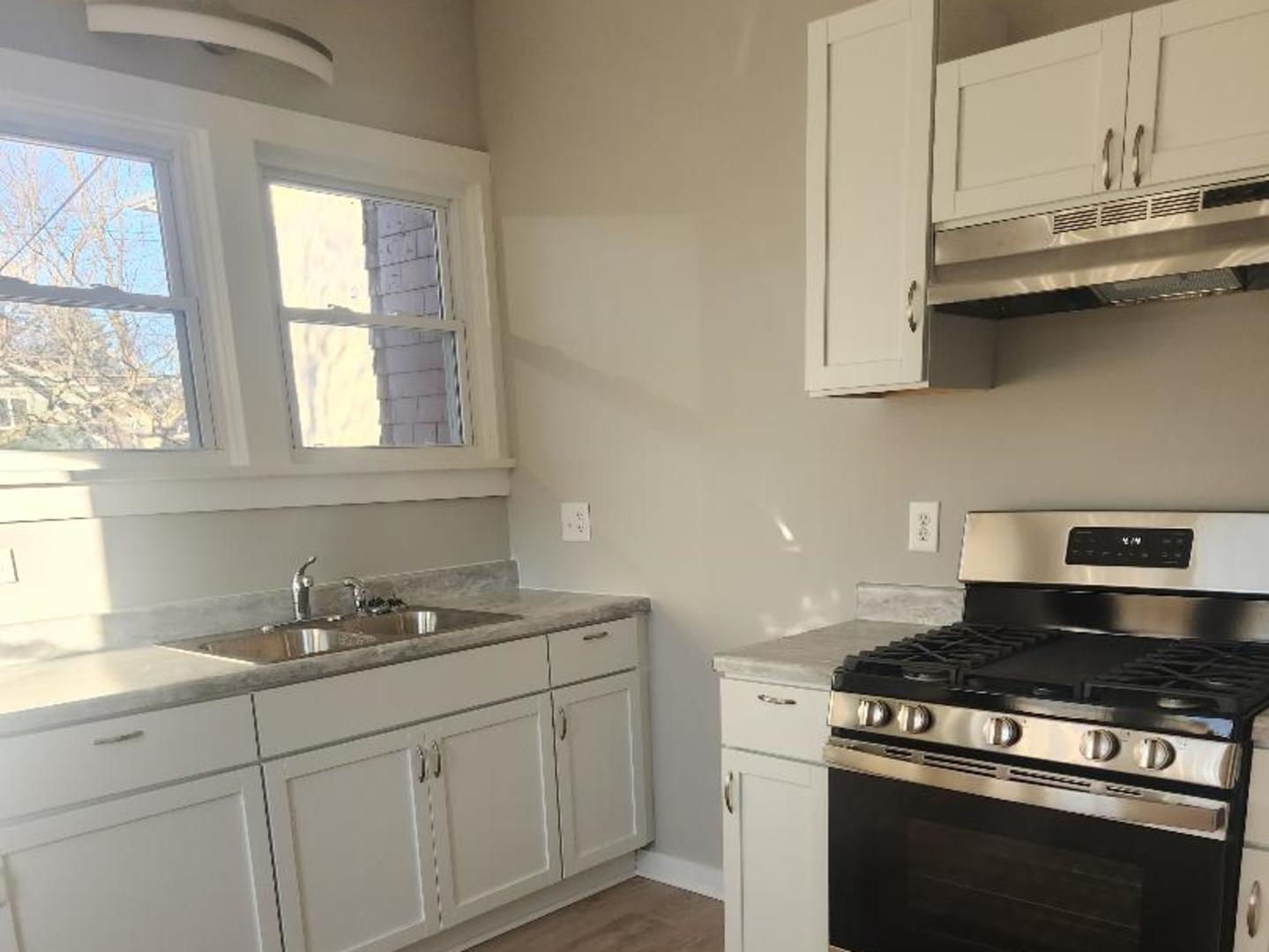 345 Augusta Avenue DeKalb, IL 60115 - Photo 20 of 25 a kitchen with stainless steel appliances granite countertop white cabinets and a stove top oven