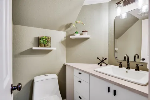 a bathroom with a sink mirror and toilet