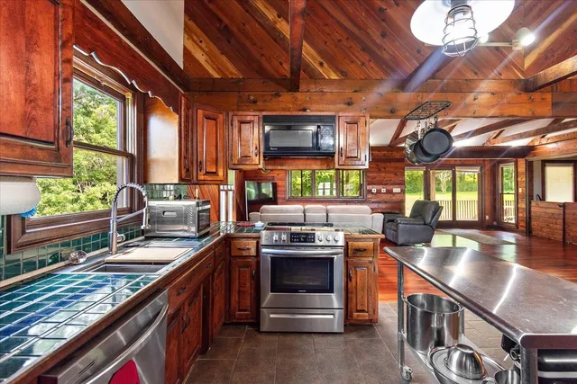 a kitchen with stainless steel appliances granite countertop a sink stove and cabinets