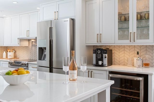 a kitchen with stainless steel appliances a refrigerator a sink a stove and cabinets