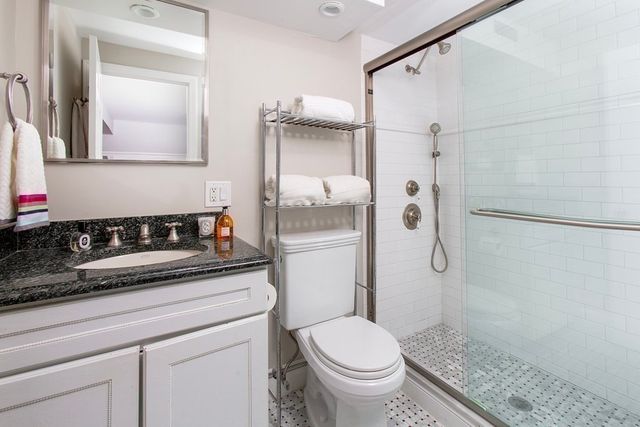 a bathroom with a granite countertop sink toilet and shower