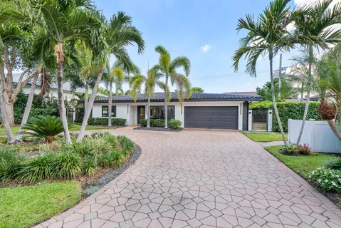 front view of a house with a yard and an trees