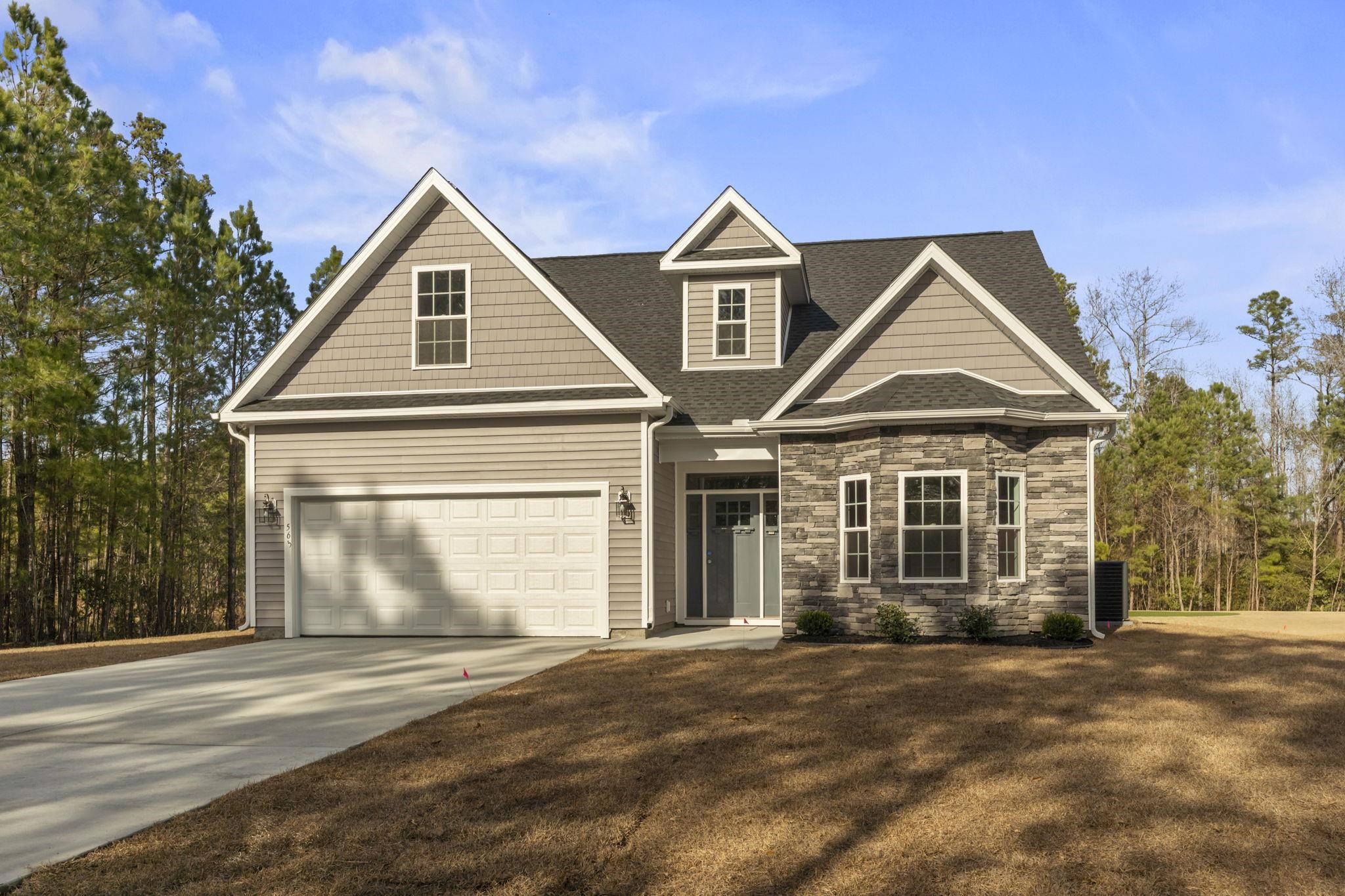 565 Timber Creek Drive Loris, SC 29569 - Photo 3 of 37 Craftsman-style house with driveway, roof with shingles, stone siding, and a front lawn