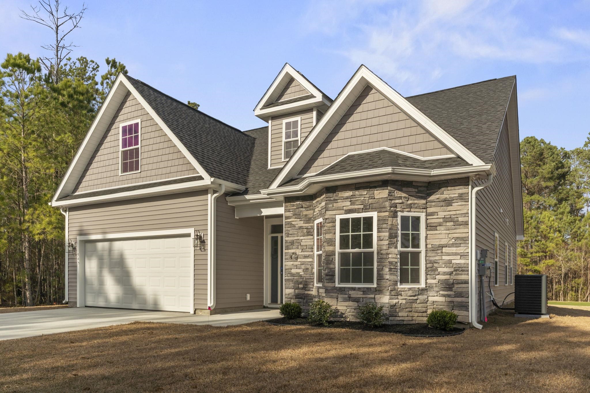 565 Timber Creek Drive Loris, SC 29569 - Photo 4 of 37 View of front of home with stone siding, a garage, driveway, and roof with shingles