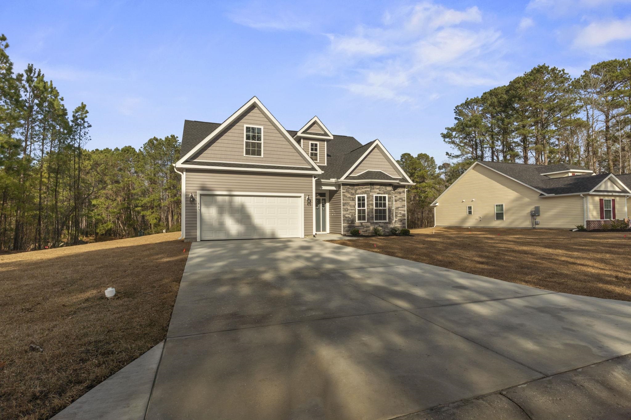 565 Timber Creek Drive Loris, SC 29569 - Photo 5 of 37 View of front of property featuring concrete driveway, a front yard, and stone siding
