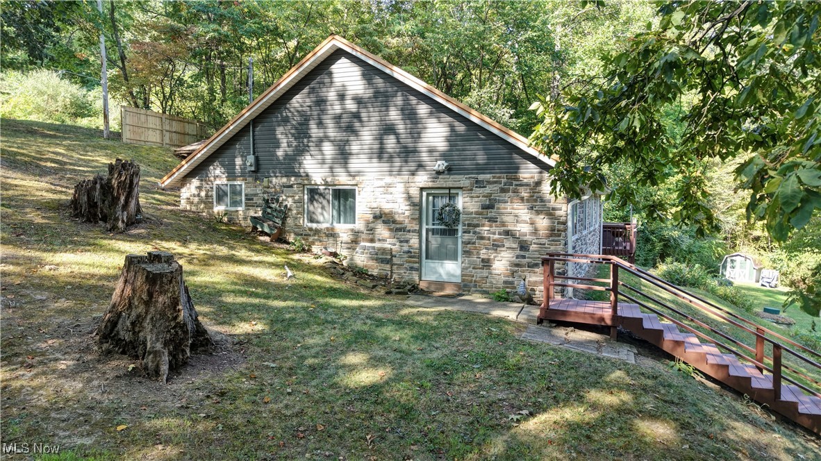 2227 Elk Road Southwest Carrollton, OH 44615 - Photo 18 of 40 Back of property featuring a lawn, stone siding, and an outdoor structure