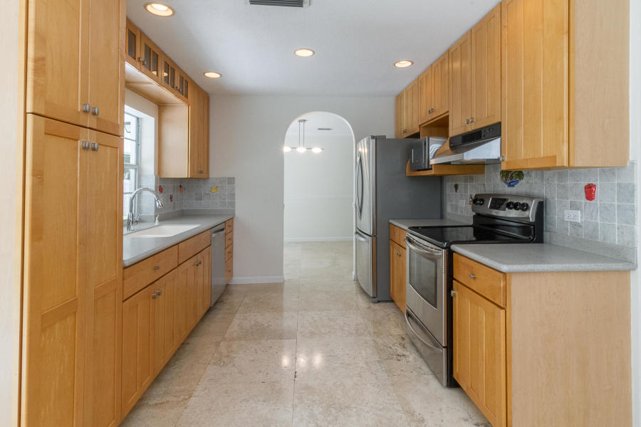 1120 Southwest 20th Street Boca Raton, FL 33486 - Photo 14 of 53 a kitchen with stainless steel appliances granite countertop a sink a stove and a refrigerator