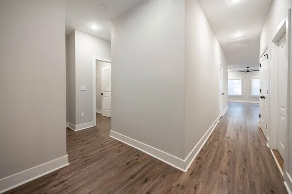 a view of a hallway with wooden floor