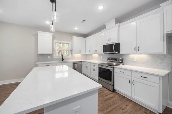 a kitchen with a sink a stove and cabinets