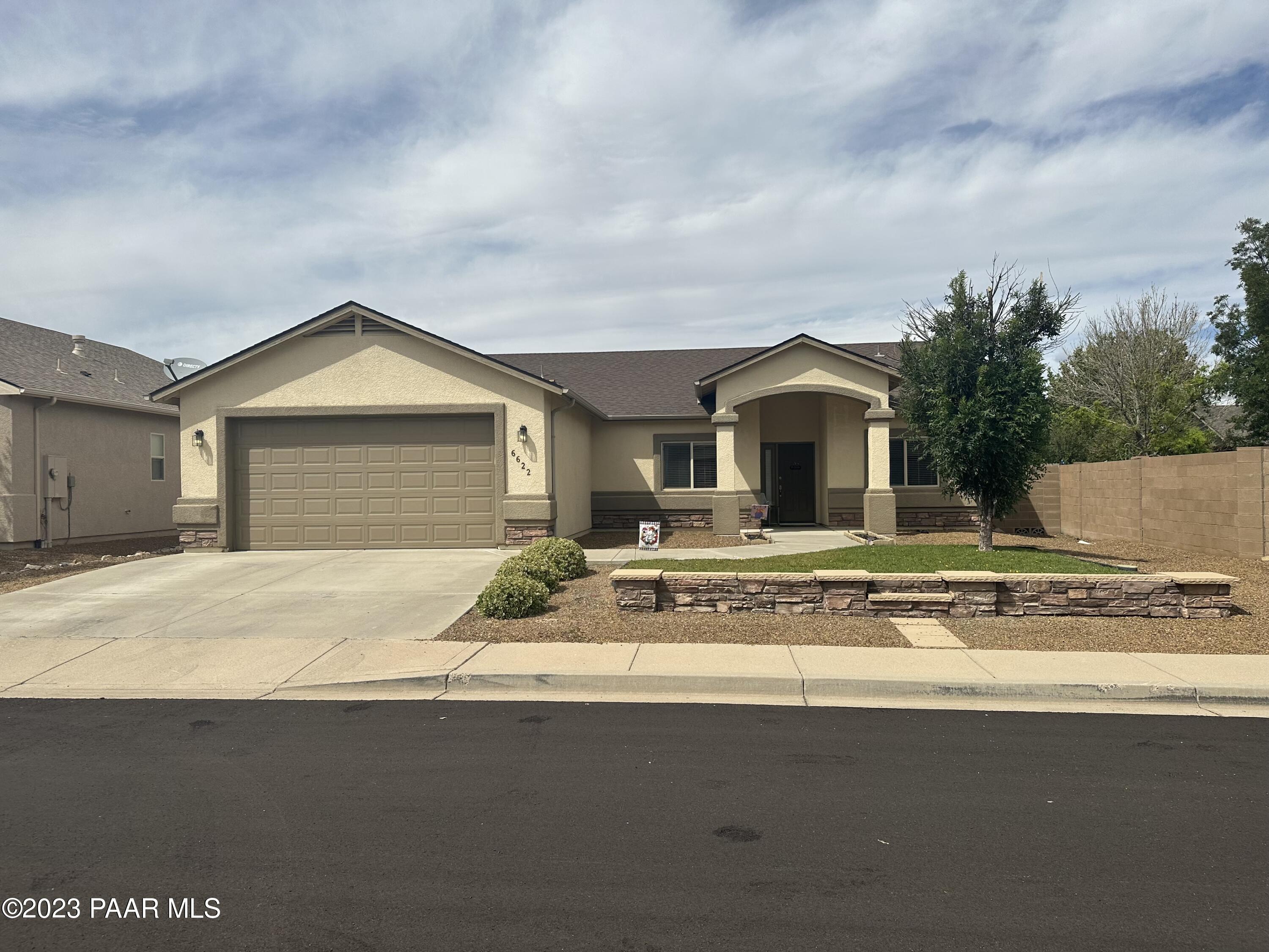 6622 Farmstead Road Prescott Valley, AZ 86314 - Photo 1 of 14 a front view of a house with a garden