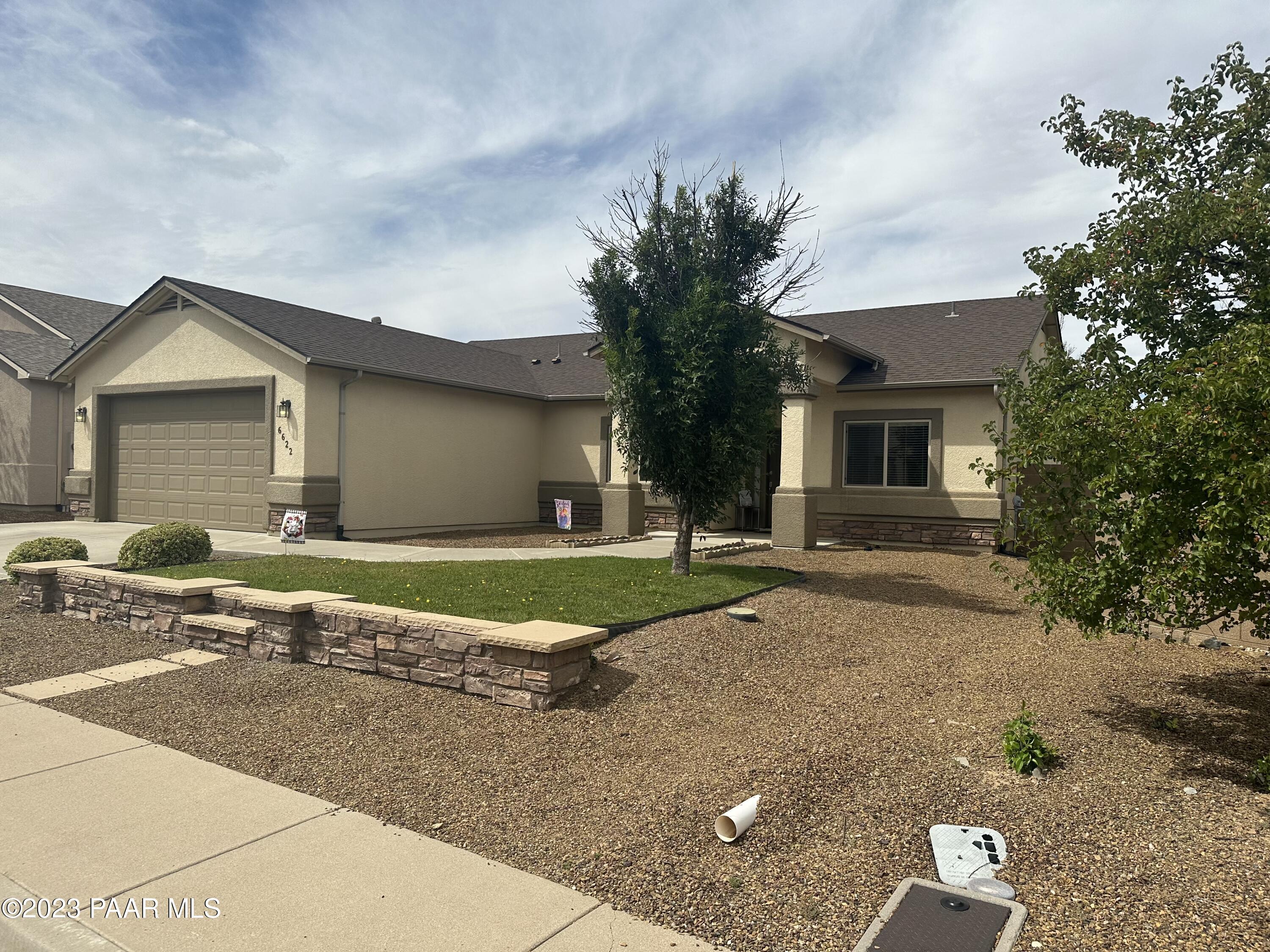 6622 Farmstead Road Prescott Valley, AZ 86314 - Photo 3 of 14 a front view of a house with a yard and garage