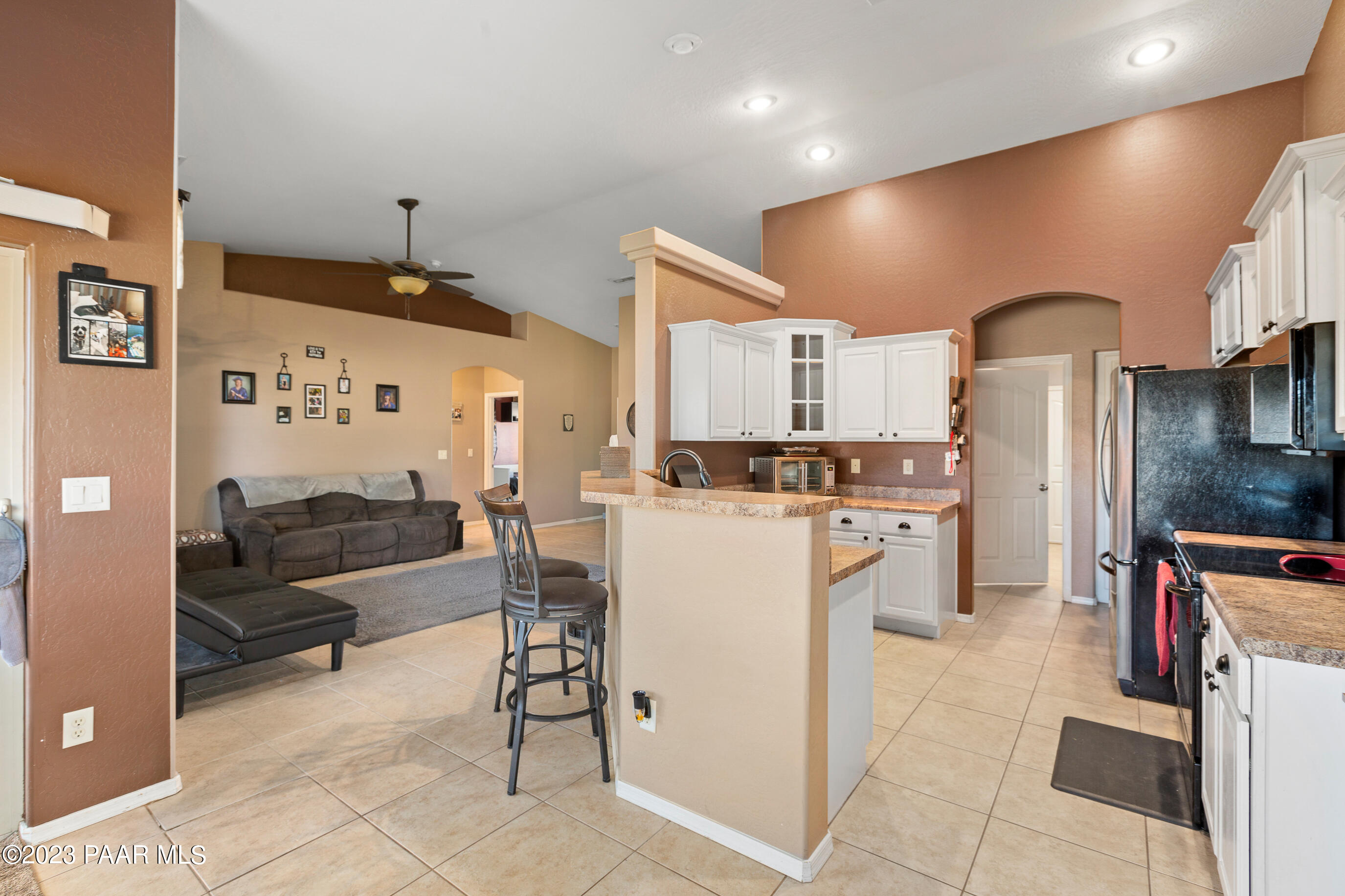 6622 Farmstead Road Prescott Valley, AZ 86314 - Photo 6 of 14 a kitchen with white cabinets and refrigerator