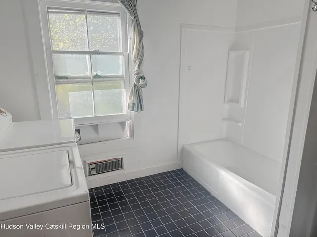 a bathroom with a bathtub and a window