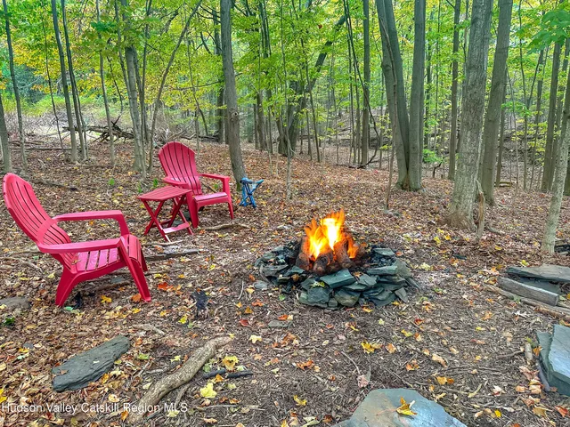 a view of a wooden chairs and fire pit in the backyard