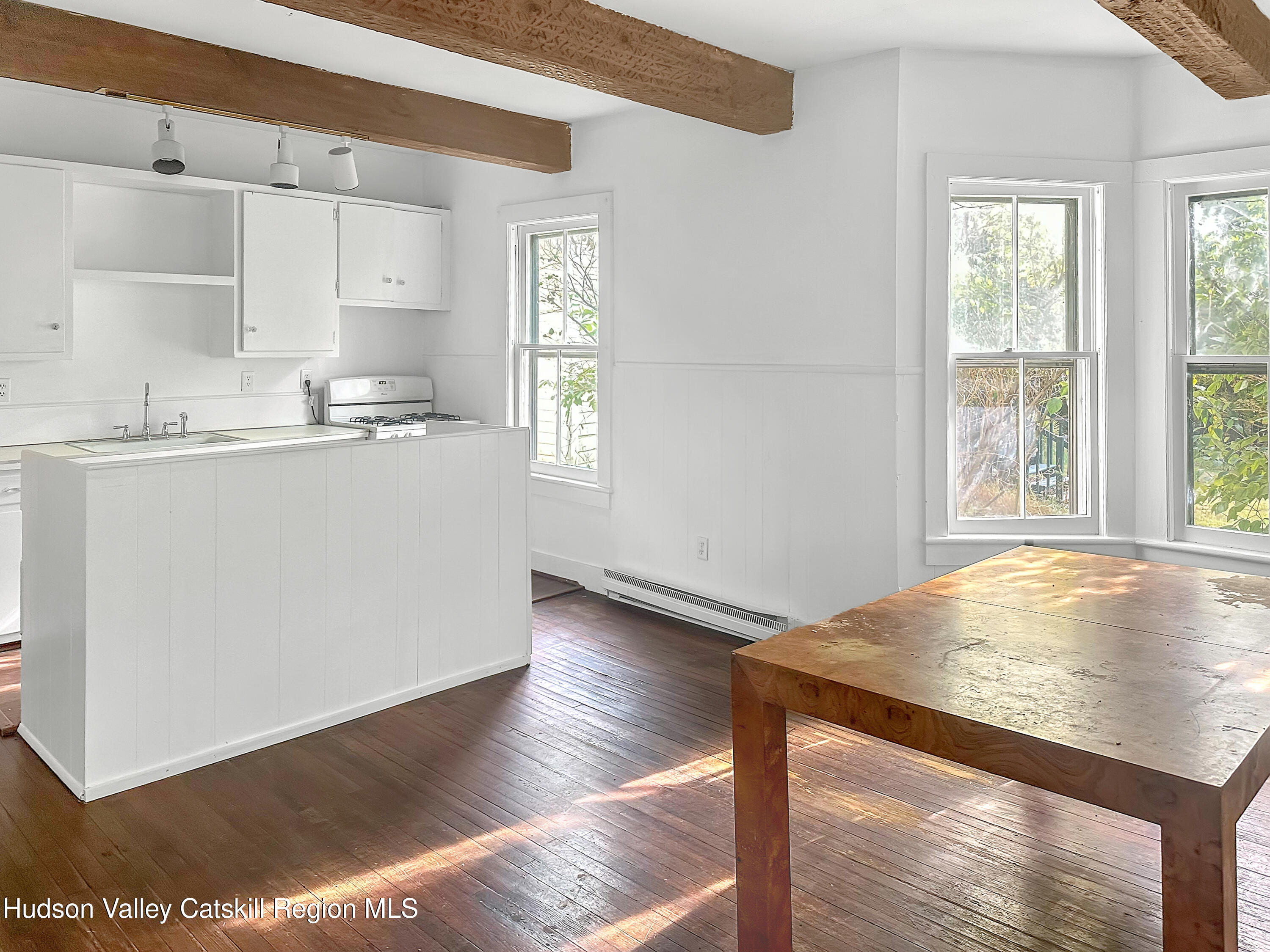 72 Meads Mountain Road, Unit 5 Woodstock, NY 12498 - Photo 5 of 20 a kitchen with stainless steel appliances granite countertop a sink stove and white cabinets with wooden floor