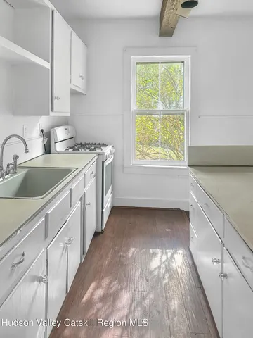 a kitchen with a sink window and cabinets
