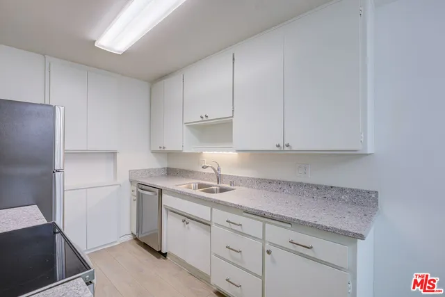 a kitchen with a sink dishwasher and cabinets